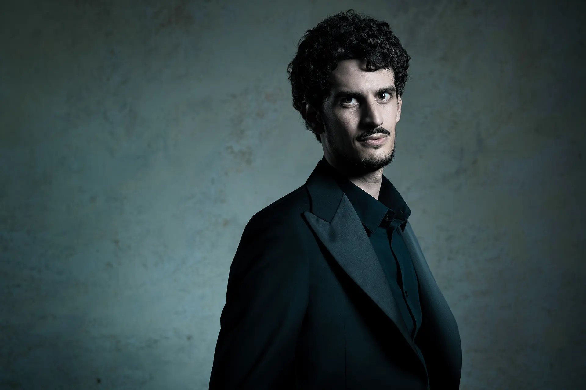 Federico Ercoli in a black jacket against a dark background.