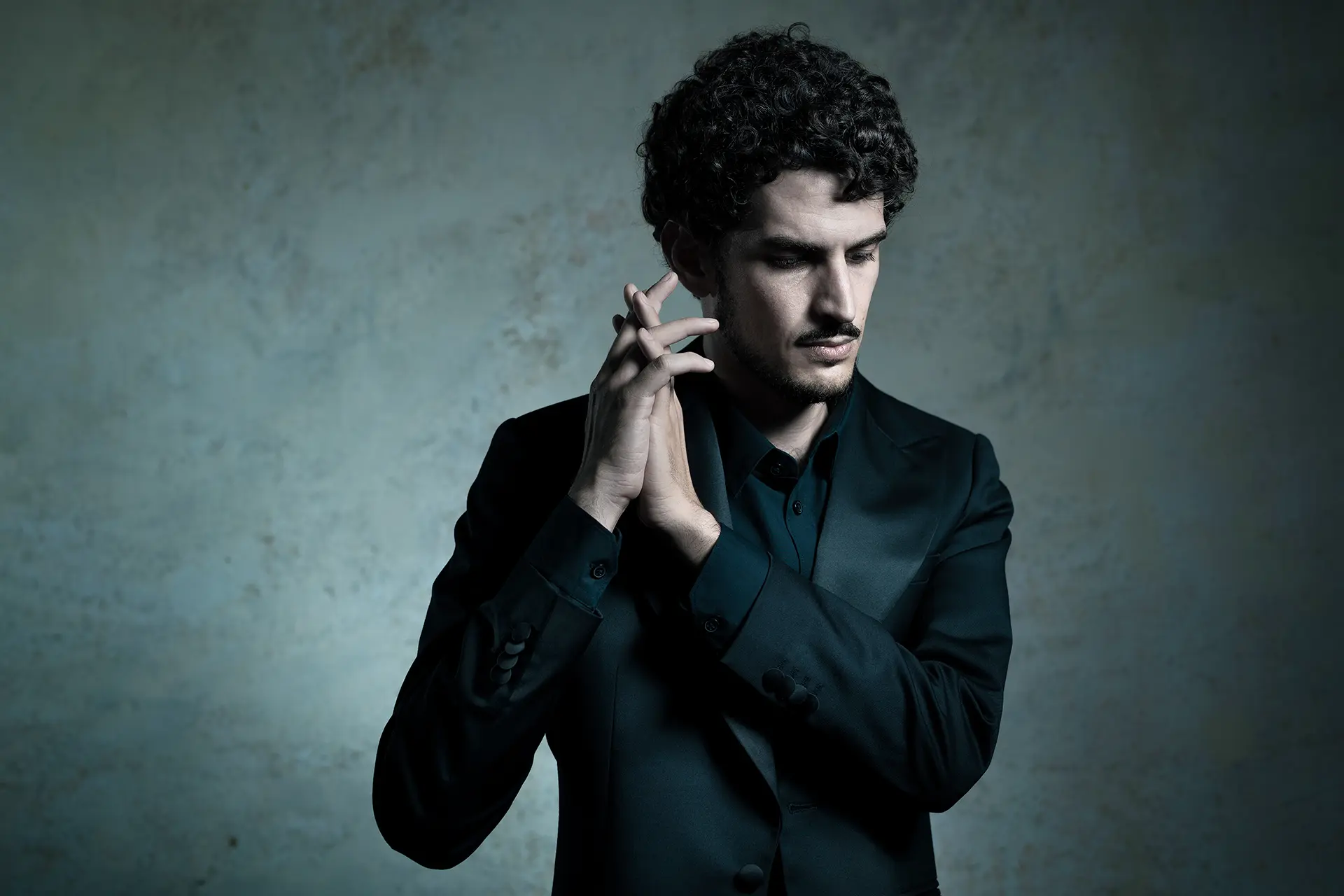 Federico Ercoli in a stylish black suit with a reflective expression.