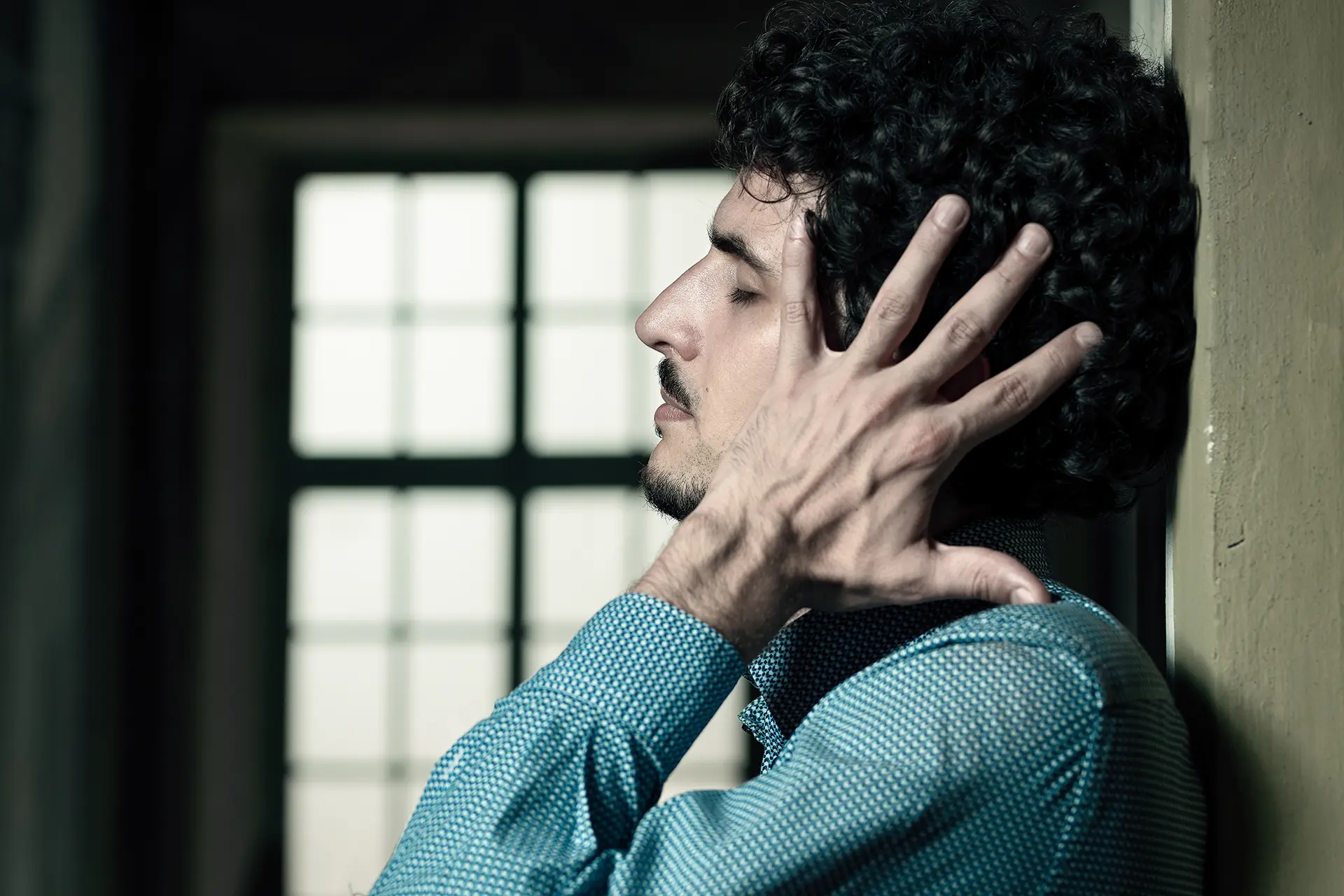 Federico Ercoli in a blue shirt standing near a closed window.