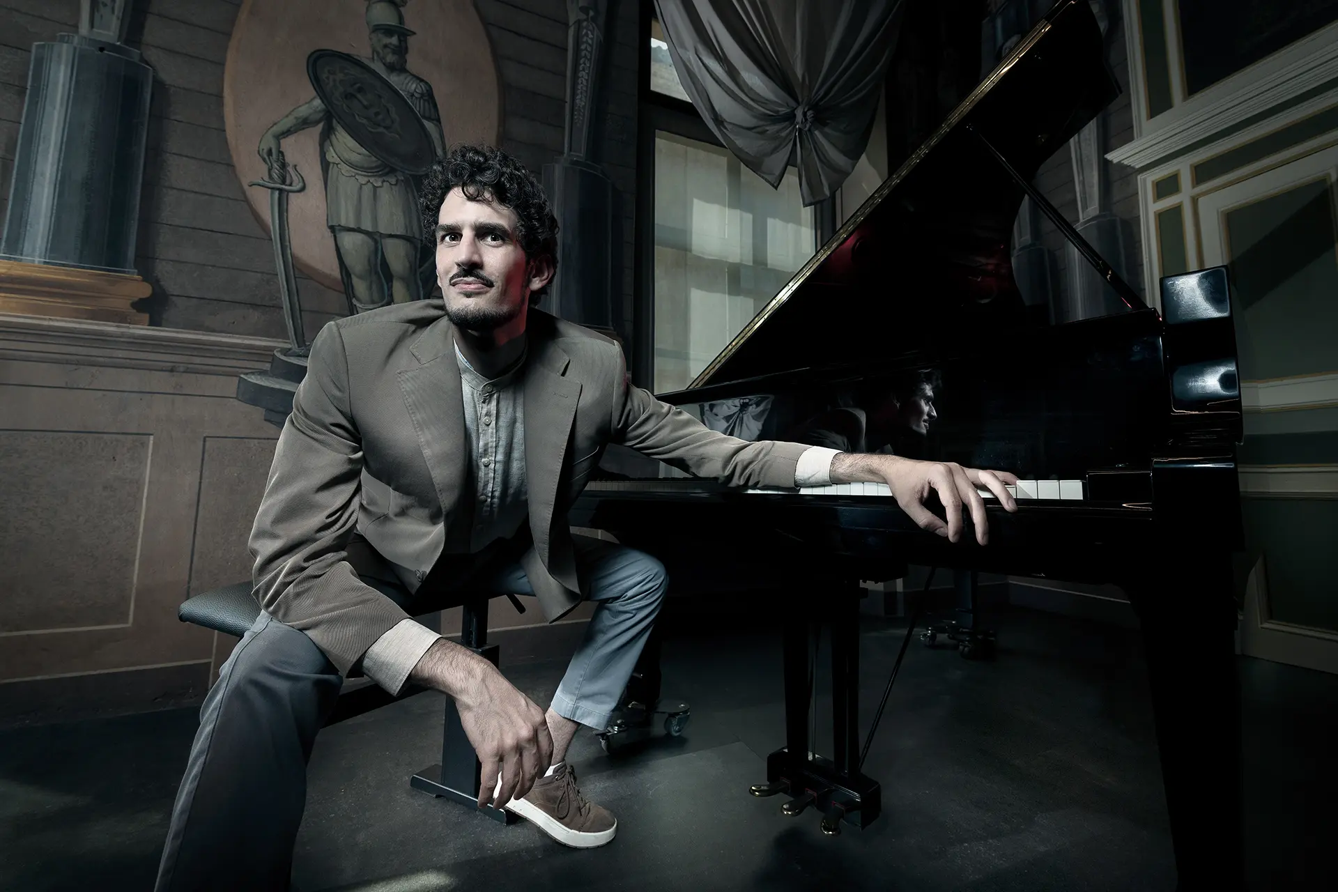 Federico Ercoli sitting next to an elegant piano.