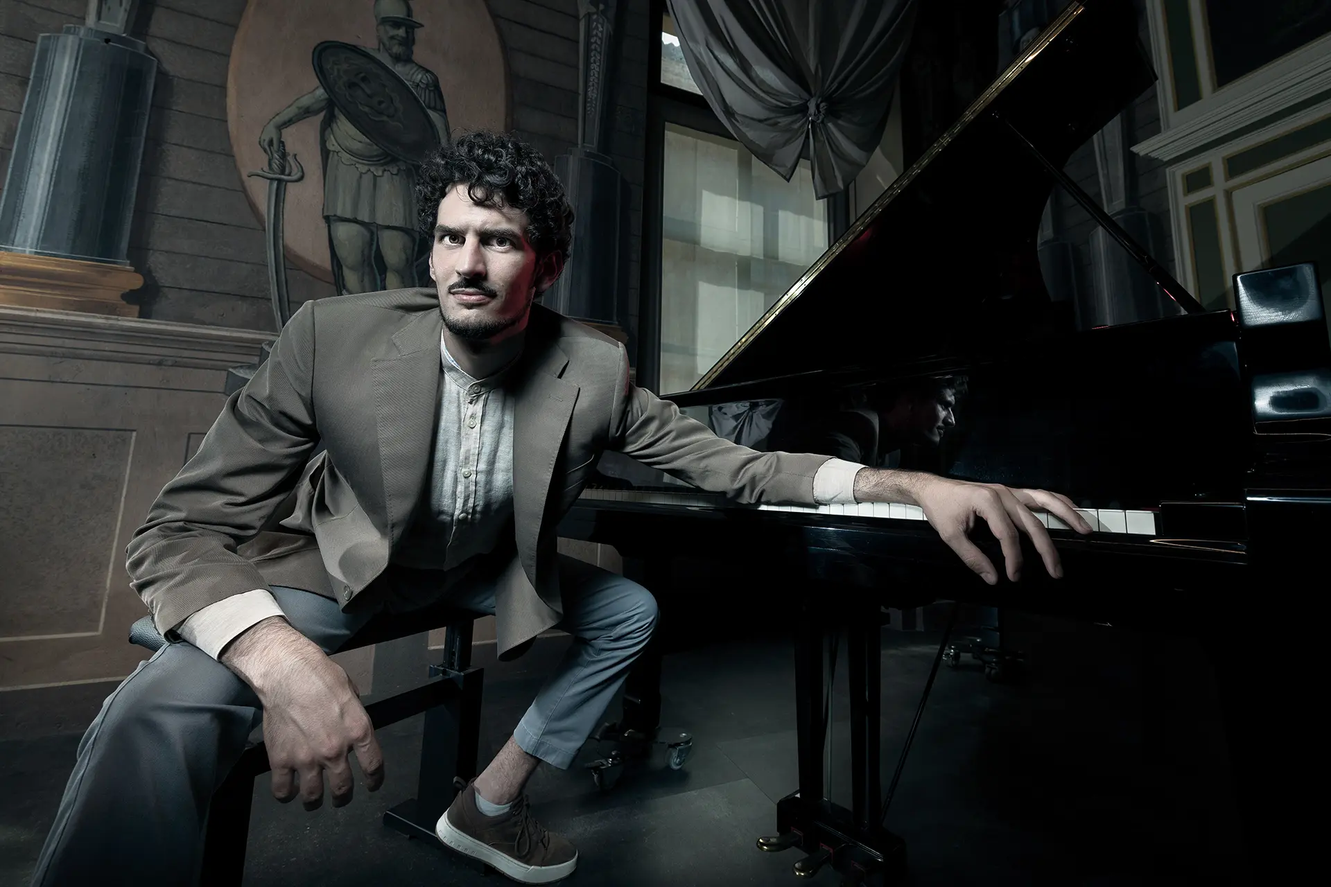 Federico Ercoli sitting at a piano in an elegant room.