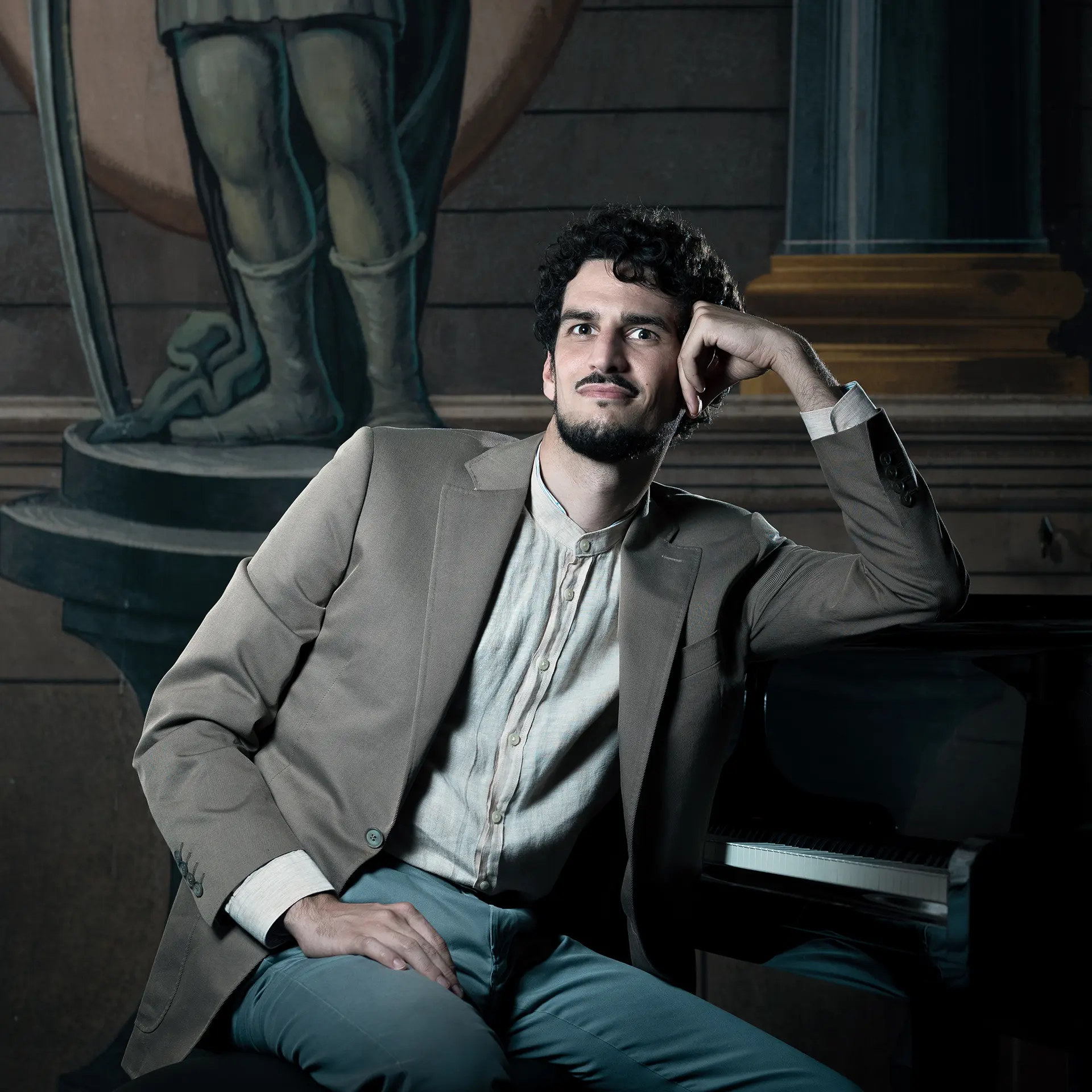 Federico Ercoli sitting next to a piano, waiting for new contacts.