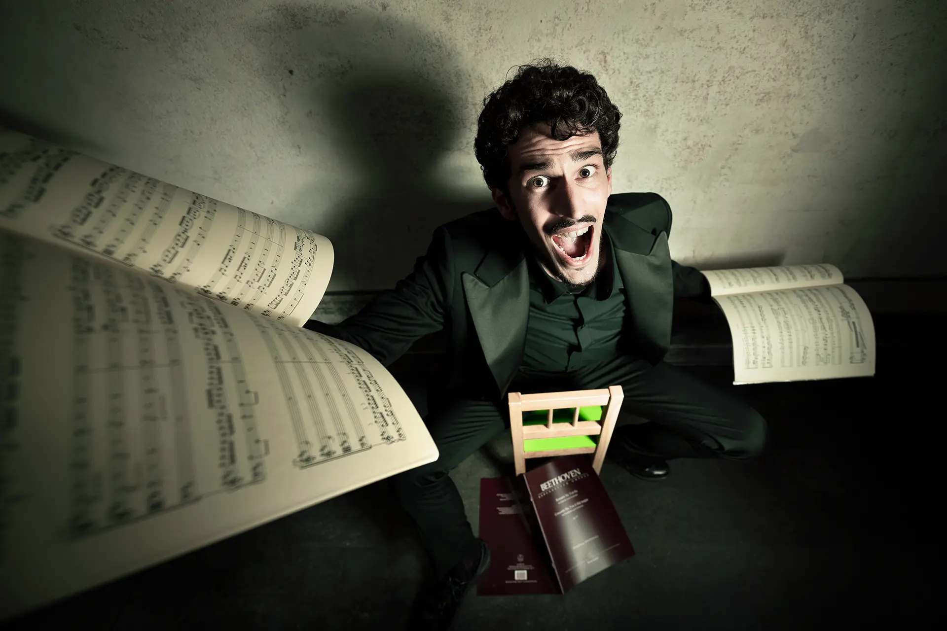 Federico Ercoli on a miniature green chair showing sheet music, for his news, events and research.